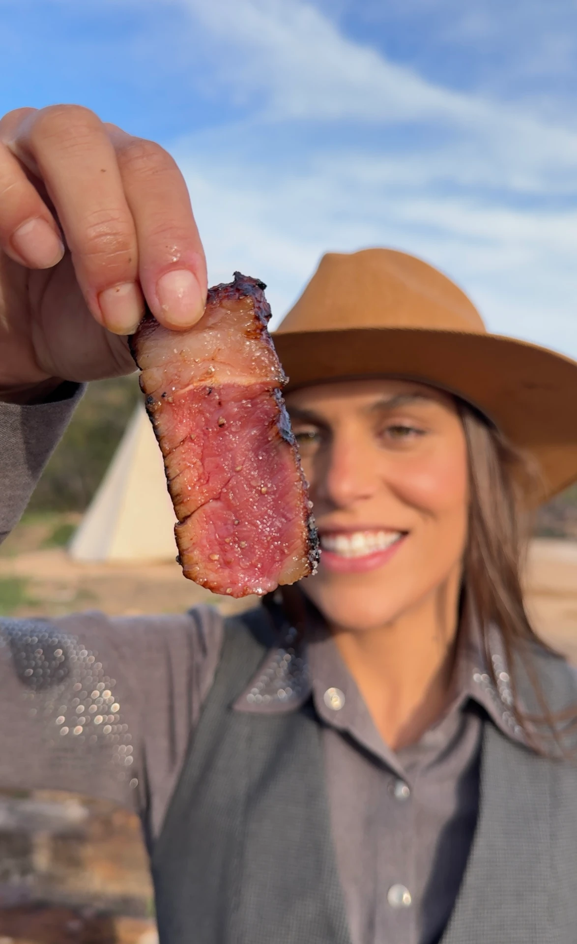 Chef Ju Lima mostrando uma fatia de carne defumada no ponto